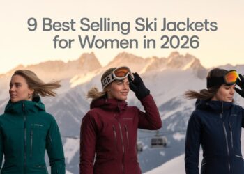 Posing on a sun-lit snowy ridge in ski jackets, alpine peaks glowing behind them, headline text across sky reads: ‘The 9 Best Selling Ski Jackets for Women in 2026.