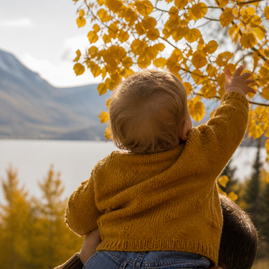 Baby wearing a mustard knit sweater outdoors for fall family photos